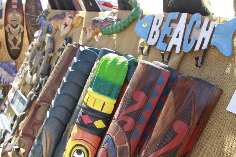 Handcrafted tiki masks at a vendor booth