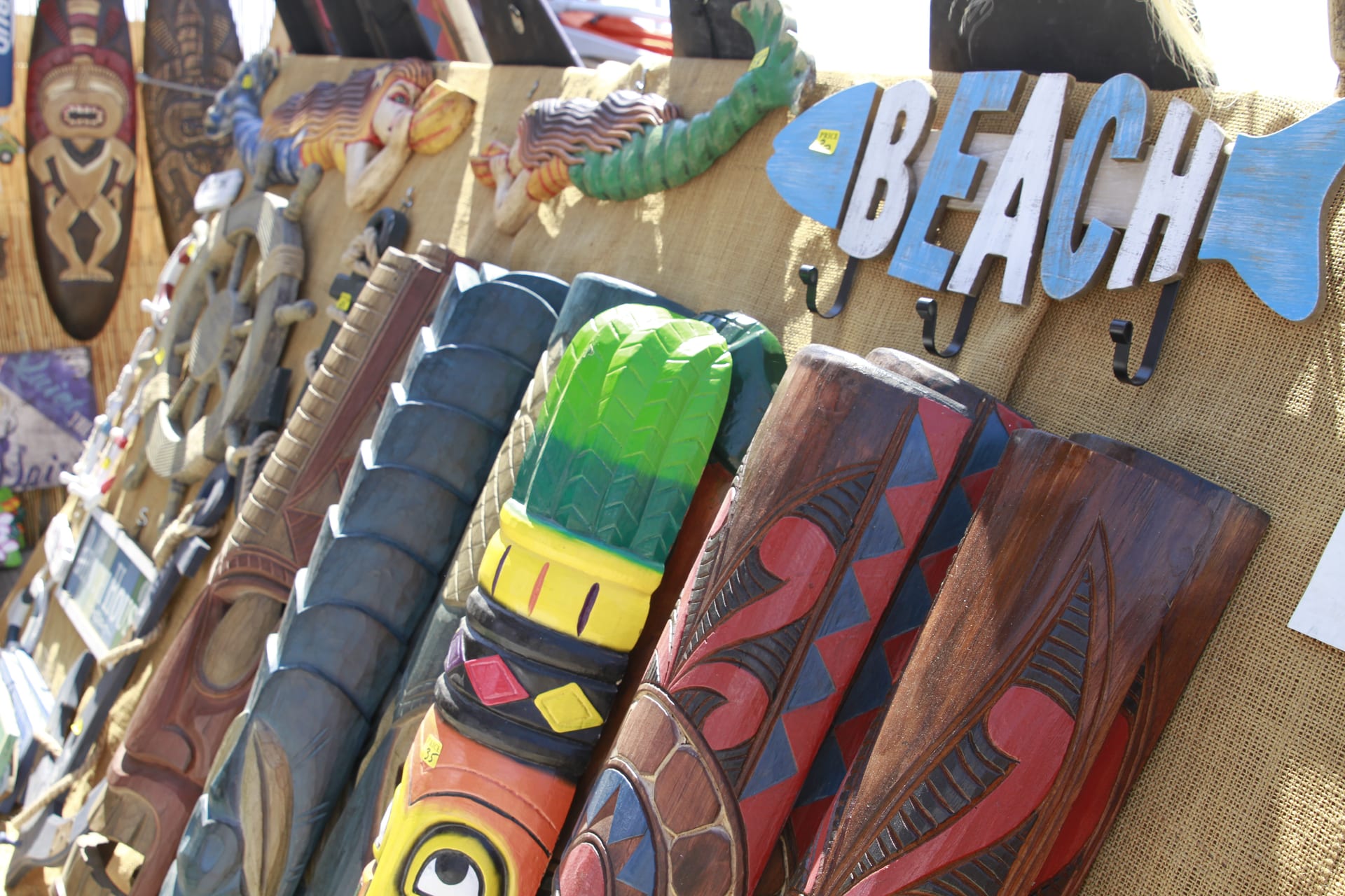 Handcrafted tiki masks at a vendor booth