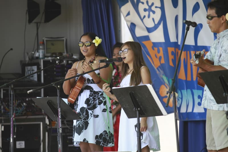 Young women singing and playing ukulele on the Main Stage