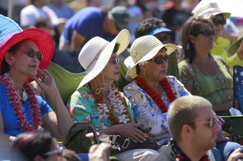Festival-goers in leis and hats enjoying the Main Stage