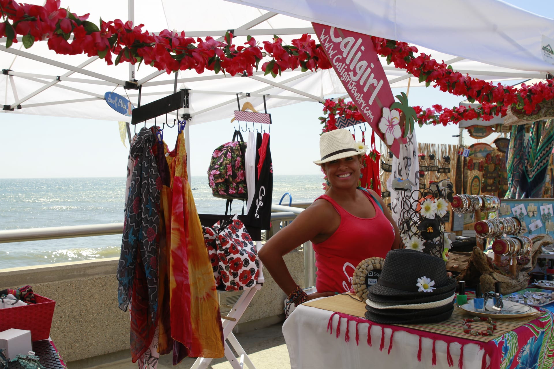 Beachfront vendor booth with scarves, hats, and accessories